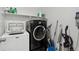 Functional laundry room with washer, dryer, shelving, and space for storage at 13221 E 110Th Pl, Commerce City, CO 80022