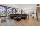 Spacious living room with black leather sectional, wood floors, and abundant natural light from the large window at 13221 E 110Th Pl, Commerce City, CO 80022
