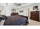 Well-lit main bedroom features a tray ceiling, ceiling fan, and dark wood furniture at 13221 E 110Th Pl, Commerce City, CO 80022