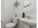 A well-lit powder room features a pedestal sink, decorative mirror, and stylish wall decor at 13221 E 110Th Pl, Commerce City, CO 80022