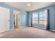 Bright bedroom with blue walls, carpet, white doors, and a view from two windows at 9515 E 109Th Cir, Commerce City, CO 80640