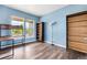 Bedroom with light blue walls, three-shelf bookcases and wood-look laminate flooring at 9515 E 109Th Cir, Commerce City, CO 80640