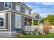 Charming gray two-story home featuring a covered porch, white trim, and manicured landscaping at 9515 E 109Th Cir, Commerce City, CO 80640