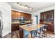 Modern kitchen with stainless appliances, granite counters, dark cabinets, a stylish island, and pendant lighting at 9515 E 109Th Cir, Commerce City, CO 80640
