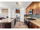 Well-lit kitchen featuring granite countertops, stainless steel appliances, and dark wood cabinetry at 9515 E 109Th Cir, Commerce City, CO 80640
