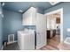 Laundry room with washer, dryer, overhead cabinets, and doorway to kitchen at 9515 E 109Th Cir, Commerce City, CO 80640