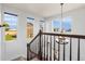 Bright stairway landing with chandelier, carpeted stairs, and backyard views from three windows at 9515 E 109Th Cir, Commerce City, CO 80640