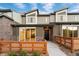Modern two-story townhome featuring wood accents, sliding glass doors, and a contemporary wood and stone fence at 12319 W 58Th Ct, Arvada, CO 80004
