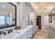 Elegant bathroom with double sinks, white cabinetry, and stylish herringbone flooring at 7452 S Utica St, Littleton, CO 80128