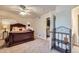 Spacious bedroom features a grand bed, soft carpet, ceiling fan, and bathroom access at 7452 S Utica St, Littleton, CO 80128