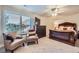 Comfortable bedroom with a luxurious bed, TV, ceiling fan, and seating area near a bright window at 7452 S Utica St, Littleton, CO 80128