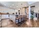 Bright kitchen with modern appliances, island seating, and hardwood floors, with stairs visible at 7452 S Utica St, Littleton, CO 80128