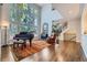 Bright living room featuring large windows, hardwood floors, and a grand piano at 7452 S Utica St, Littleton, CO 80128