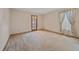Unfurnished bedroom with neutral carpet, a window with curtains, and door offering outdoor access at 31 Irene Ct, Broomfield, CO 80020