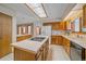 Spacious kitchen features oak cabinetry, a central island with cooktop, and ample natural light at 31 Irene Ct, Broomfield, CO 80020
