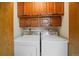 Functional laundry room with side-by-side washer and dryer, complemented by overhead wooden cabinetry at 31 Irene Ct, Broomfield, CO 80020
