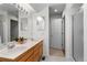 Bathroom with double sinks, tile floor, a shower, and a doorway view to another room at 12502 E Harvard Cir, Aurora, CO 80014