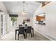 Bright dining room featuring a chandelier, a pass-through bar to the kitchen, and a window view to the outside at 12502 E Harvard Cir, Aurora, CO 80014
