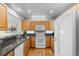 Well-lit kitchen boasting wooden cabinets, granite counters, a white refrigerator, oven, and an eat in bar at 12502 E Harvard Cir, Aurora, CO 80014