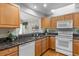 Charming kitchen with wooden cabinets, granite counters, stainless steel sink, and pass through bar to dining room at 12502 E Harvard Cir, Aurora, CO 80014