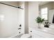 Bright bathroom features a white vanity, white tile shower, and modern matte black fixtures at 6303 Elmira St, Denver, CO 80238