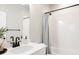 Bathroom featuring a white vanity, white tile shower, and modern matte black fixtures at 6303 Elmira St, Denver, CO 80238