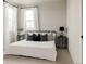 Bright bedroom showcasing a metal frame bed, stylish pillows, and two windows with sheer curtains at 6303 Elmira St, Denver, CO 80238