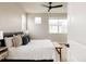 Inviting bedroom with a bench, a ceiling fan, and a bed with decorative pillows at 6303 Elmira St, Denver, CO 80238