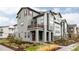 Modern three-story townhome with stylish gray exterior, balcony, and professionally landscaped front yard at 6303 Elmira St, Denver, CO 80238