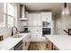 Modern kitchen equipped with stainless steel appliances and sleek white cabinetry at 6303 Elmira St, Denver, CO 80238