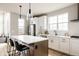 Stylish kitchen featuring a large island with bar seating and modern pendant lighting at 6303 Elmira St, Denver, CO 80238