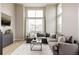 Bright living room features large windows, tall ceilings, and a comfortable gray sectional sofa at 6303 Elmira St, Denver, CO 80238