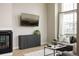 Cozy living room with fireplace, large window, mounted TV, and comfortable gray sofa at 6303 Elmira St, Denver, CO 80238