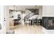 Open living space with kitchen island, dining area, fireplace, and hardwood floors at 6303 Elmira St, Denver, CO 80238