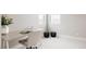 Office features a desk, comfortable chair, two windows, and neutral carpeting at 6303 Elmira St, Denver, CO 80238