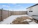 Backyard featuring a wooden fence and partially snow-covered grass, offering privacy at 5584 Moosehead Cir, Longmont, CO 80504