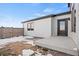 Exterior view of backyard with a small patio and partially snow-covered grass at 5584 Moosehead Cir, Longmont, CO 80504