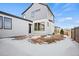 Exterior view of modern home with grey siding and white accents, featuring a small backyard at 5584 Moosehead Cir, Longmont, CO 80504