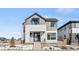 Modern two-story home featuring mixed siding, a small front porch, and landscaped front yard with some snow at 5584 Moosehead Cir, Longmont, CO 80504