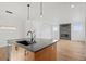 Open-concept kitchen with island, hardwood floors, and a glimpse of the living room's modern fireplace at 5584 Moosehead Cir, Longmont, CO 80504