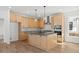 Modern kitchen featuring wood cabinets, stainless steel appliances, gray countertops, and hardwood floors at 5584 Moosehead Cir, Longmont, CO 80504