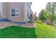 Backyard view showcasing the lawn, home exterior, and access stairs to an outdoor patio or upper level deck at 16021 Williams Pl, Broomfield, CO 80023
