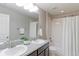 Bathroom with a double-sink vanity, granite countertop, and a shower/tub combo with white tile surround at 16021 Williams Pl, Broomfield, CO 80023