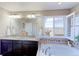 Bright bathroom with double sinks, soaking tub, and a scenic window view at 16021 Williams Pl, Broomfield, CO 80023