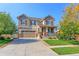 Charming two-story home boasting a well-manicured lawn, mature trees, and inviting front porch with stone accents at 16021 Williams Pl, Broomfield, CO 80023