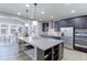 Modern kitchen with large granite island, stainless steel appliances, dark wood cabinets, and pendant lighting at 16021 Williams Pl, Broomfield, CO 80023