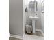 Compact powder room with white pedestal sink, round mirror, and decorative accents at 16021 Williams Pl, Broomfield, CO 80023