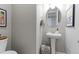 Elegant powder room featuring pedestal sink, decorative mirror, and stylish accent at 16021 Williams Pl, Broomfield, CO 80023