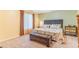 Comfortable bedroom with a queen bed, cushioned bench, bedside table, and plenty of natural light from large window at 5320 E 100Th Dr, Thornton, CO 80229