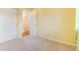 A well-lit bedroom with empty tan carpet and yellow walls, with an entrance to a closet at 5320 E 100Th Dr, Thornton, CO 80229